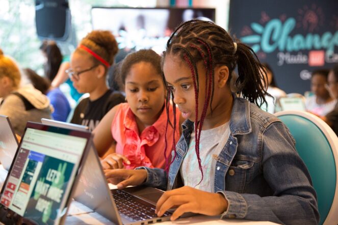 2 young girls working on a laptop